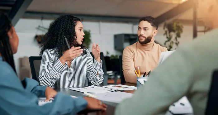 Two colleagues talking through a candidate profile across a table