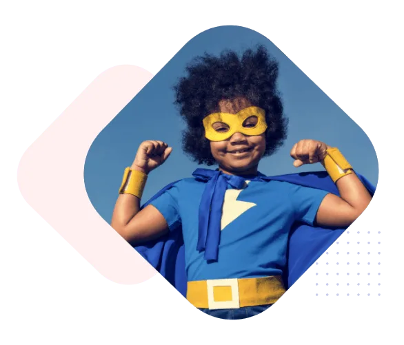 A child in a superhero cape and mask flexing against a blue sky
