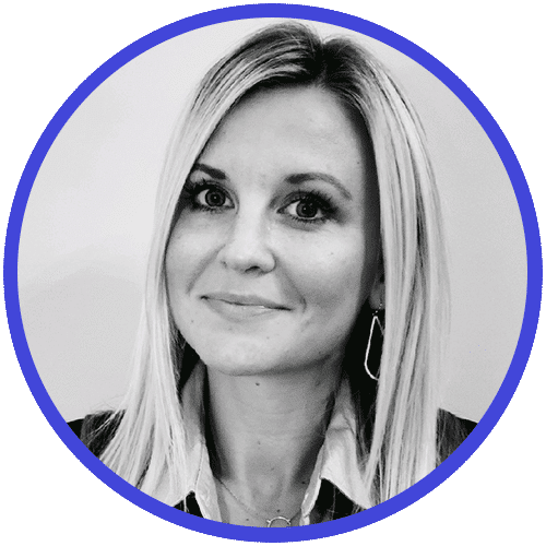 Black and white portrait of a person with long, light hair smiling softly. They are wearing a collared shirt and drop earrings, exuding the poised confidence often seen in sales assessments. The photo is enclosed in a circular, blue border.